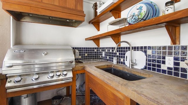 kitchen featuring a sink, under cabinet range hood, decorative backsplash, and open shelves