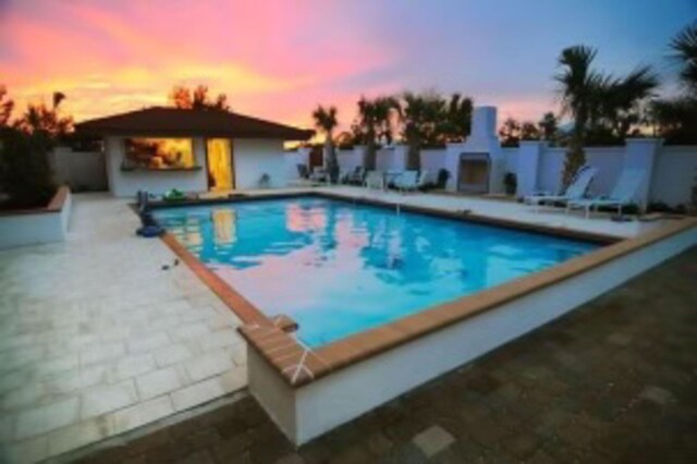 outdoor pool with a patio area and fence