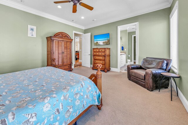 carpeted bedroom with ceiling fan, ornamental molding, and ensuite bath