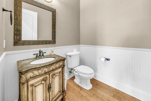 bathroom with vanity, toilet, and hardwood / wood-style floors