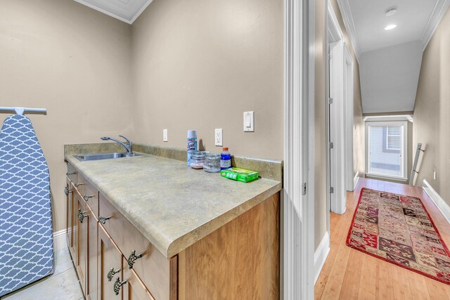 interior space with ornamental molding, light hardwood / wood-style flooring, and sink