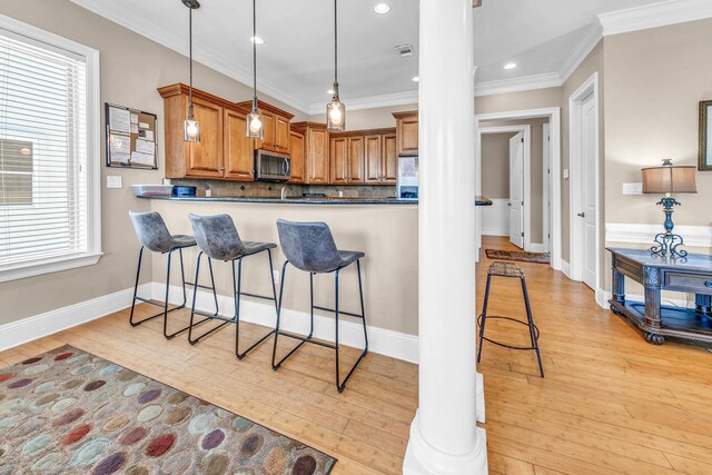 kitchen with kitchen peninsula, light hardwood / wood-style floors, tasteful backsplash, and a healthy amount of sunlight