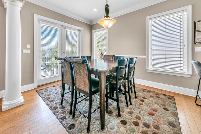 dining area featuring decorative columns, light hardwood / wood-style floors, and crown molding