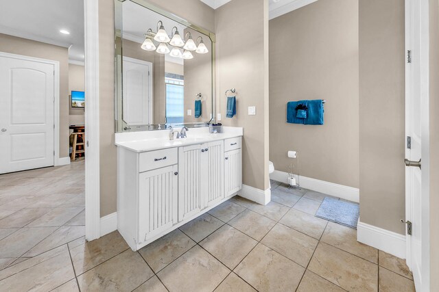 bathroom with vanity, toilet, ornamental molding, and tile patterned floors