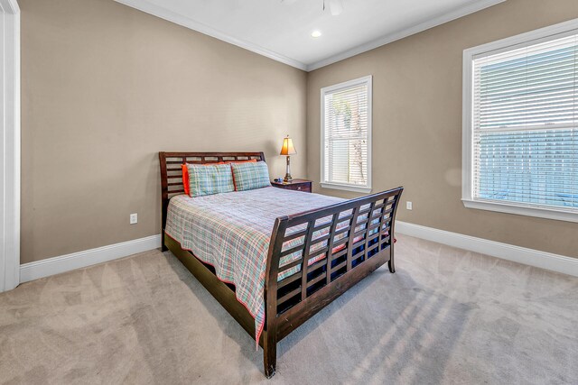 carpeted bedroom with ceiling fan and crown molding