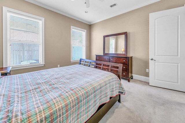 bedroom featuring ceiling fan, light carpet, and ornamental molding