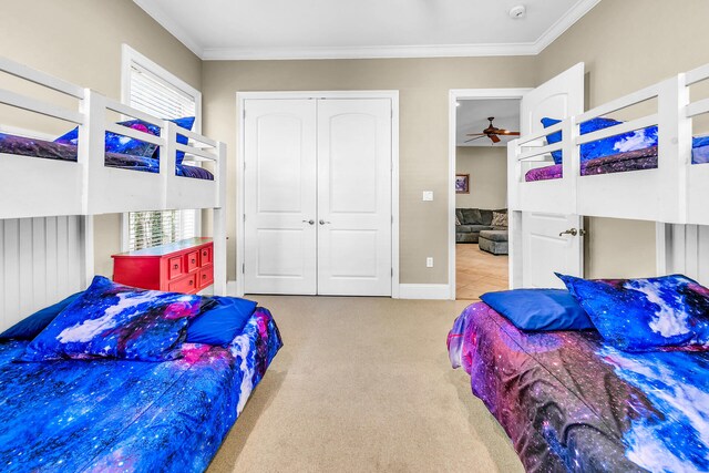 carpeted bedroom with ornamental molding and a closet