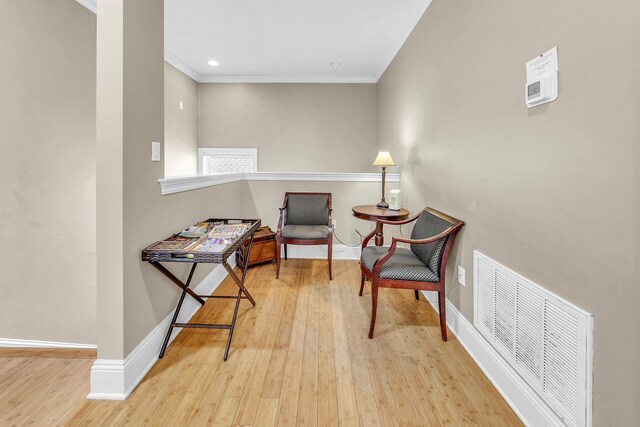 sitting room featuring light hardwood / wood-style floors and crown molding