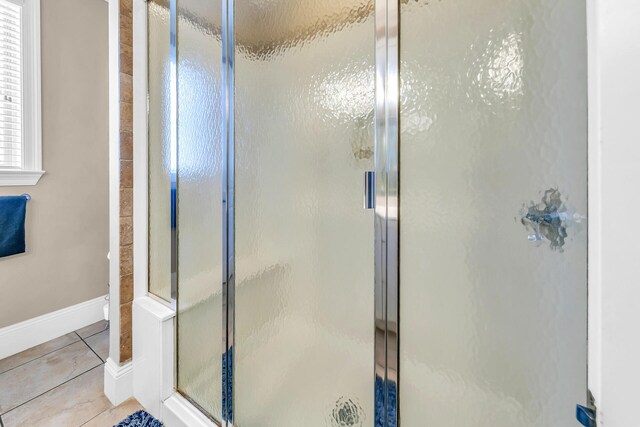 bathroom with tile patterned flooring and a shower with shower door