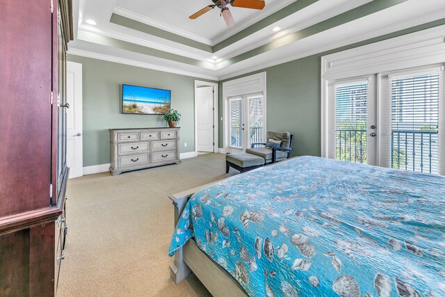 carpeted bedroom featuring french doors, ceiling fan, multiple windows, and a tray ceiling