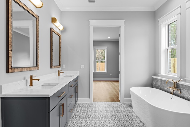 bathroom featuring vanity, ornamental molding, a bath, and a wealth of natural light