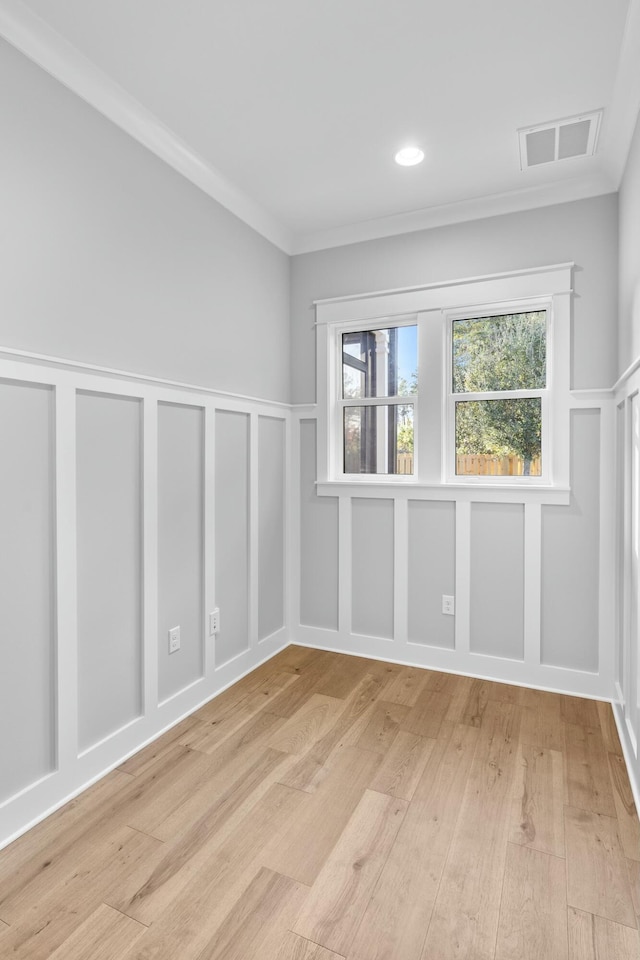 spare room with crown molding and light hardwood / wood-style flooring