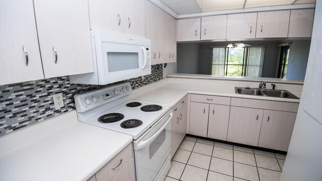 kitchen with light tile patterned floors, white appliances, backsplash, and sink