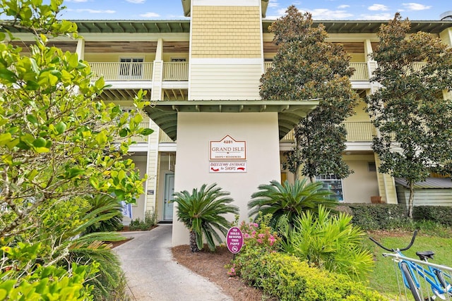 view of exterior entry with a balcony