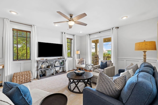 living room with light hardwood / wood-style flooring, ceiling fan, a wealth of natural light, and french doors