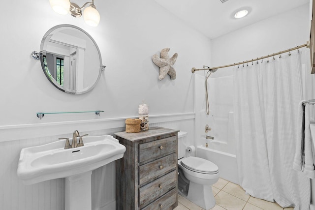 full bathroom featuring tile patterned flooring, toilet, shower / tub combo with curtain, and sink