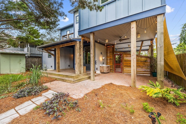 rear view of house with a patio and a shed