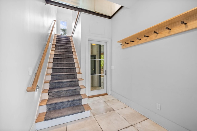 staircase with plenty of natural light and tile patterned floors