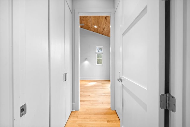 hall with light wood-type flooring, wood ceiling, and lofted ceiling