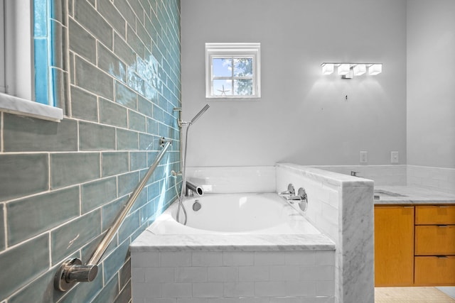 bathroom with tiled tub and sink