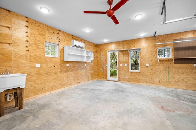 interior space with ceiling fan, a wall unit AC, and wooden walls