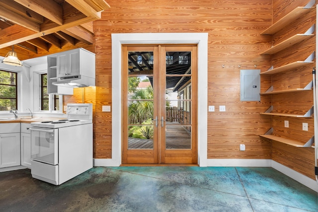 kitchen with white electric range, white cabinets, decorative light fixtures, and wood walls