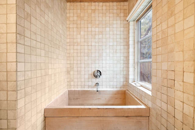 bathroom featuring a tub and tile walls