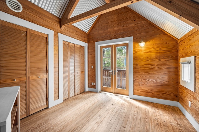 interior space featuring lofted ceiling with beams and french doors