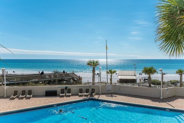 view of swimming pool with a view of the beach and a water view