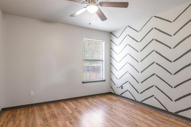 spare room featuring a textured ceiling, ceiling fan, and wood-type flooring