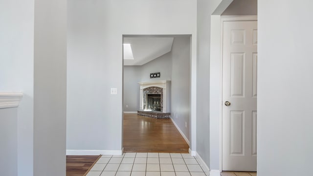 hall featuring lofted ceiling and light hardwood / wood-style flooring