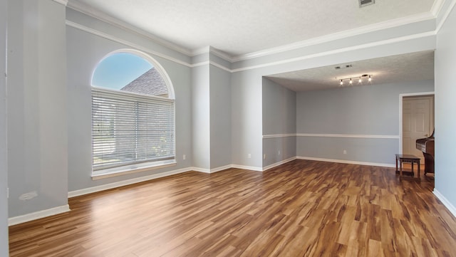 unfurnished room with crown molding, a textured ceiling, and hardwood / wood-style floors