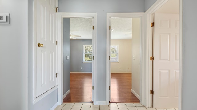 corridor featuring a textured ceiling and light wood-type flooring