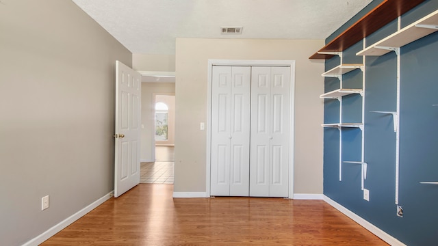 unfurnished bedroom featuring wood-type flooring and a closet