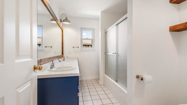 bathroom featuring tile patterned flooring, vanity, and enclosed tub / shower combo