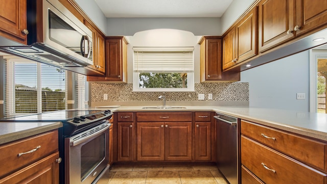 kitchen featuring a wealth of natural light, stainless steel appliances, sink, and decorative backsplash