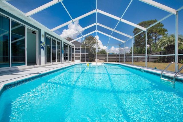 view of swimming pool featuring glass enclosure