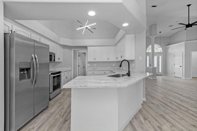 kitchen featuring light wood-type flooring, appliances with stainless steel finishes, ceiling fan with notable chandelier, and kitchen peninsula