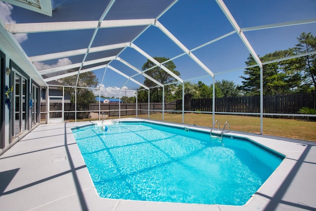 view of pool featuring a lawn, a lanai, and a patio area