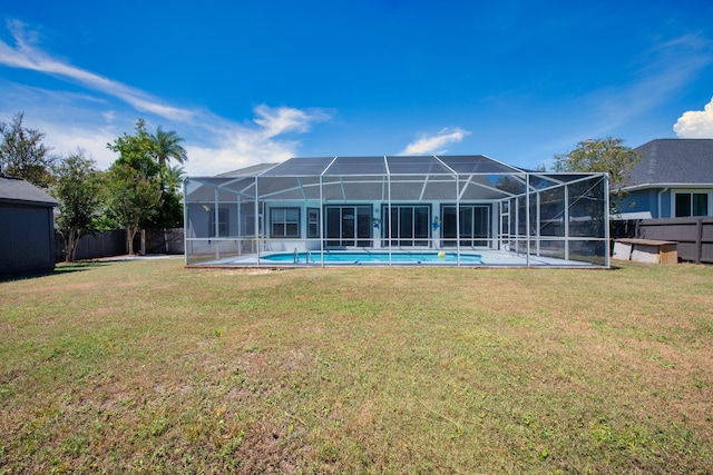 rear view of property featuring a lawn, a fenced in pool, and glass enclosure