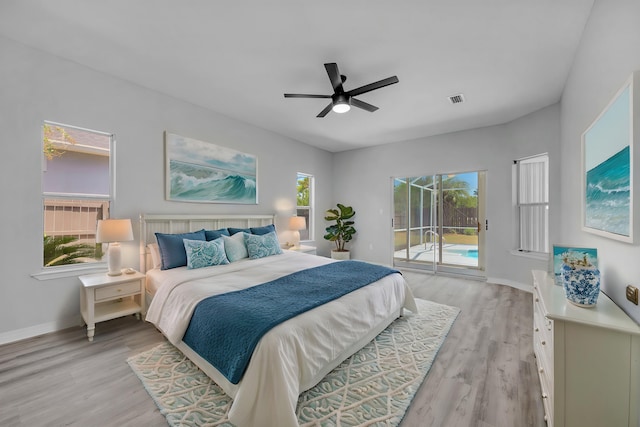 bedroom featuring multiple windows, access to exterior, and light hardwood / wood-style flooring