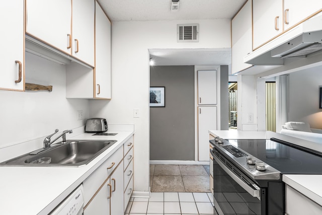 kitchen featuring sink, stainless steel electric range, white cabinetry, and light tile patterned flooring