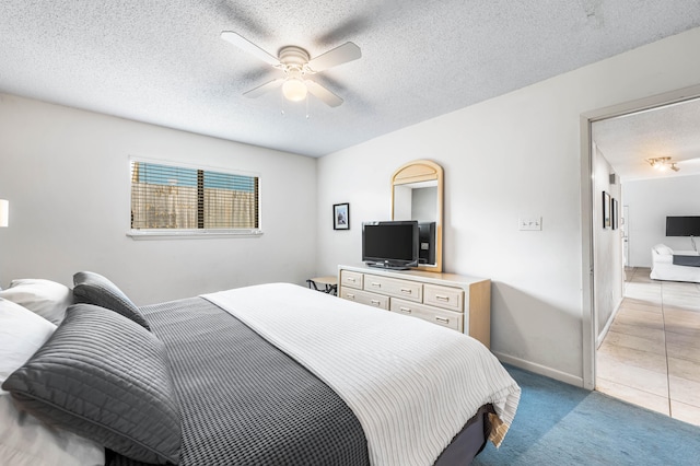 bedroom featuring a textured ceiling, ceiling fan, and light carpet