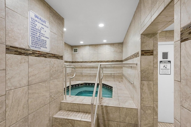 view of swimming pool with an indoor hot tub