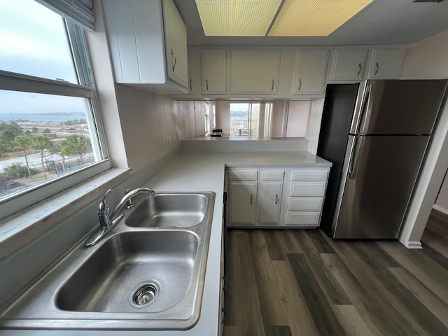 kitchen with dark wood-style floors, light countertops, a sink, and freestanding refrigerator