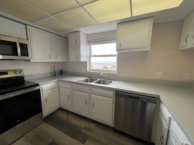 kitchen with light countertops, appliances with stainless steel finishes, a sink, and white cabinetry