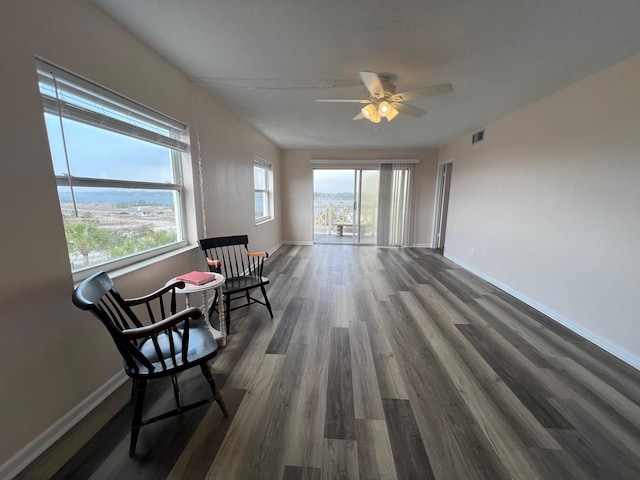 sitting room with dark wood finished floors, visible vents, and baseboards