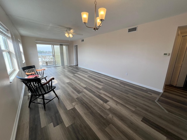 interior space featuring visible vents, baseboards, wood finished floors, and ceiling fan with notable chandelier