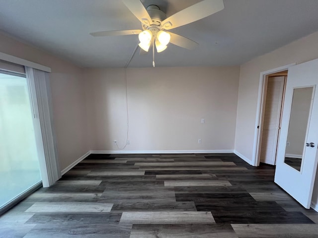 spare room with wood finished floors, a ceiling fan, and baseboards