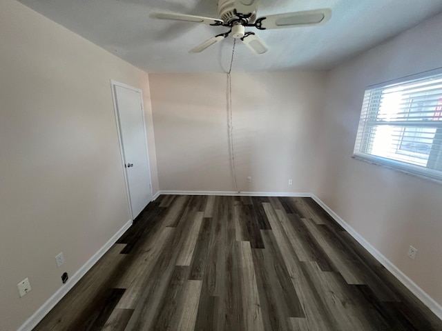 empty room with dark wood-type flooring, baseboards, and a ceiling fan